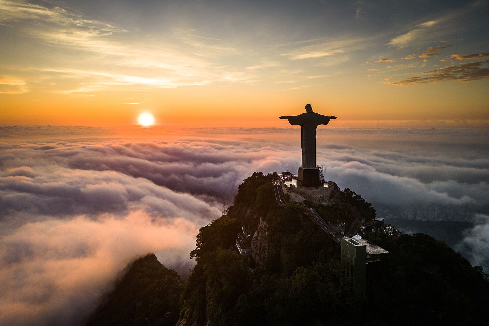 Cristo Redentor no alto do Corcovado, acima das nuvens, ao nascer do sol